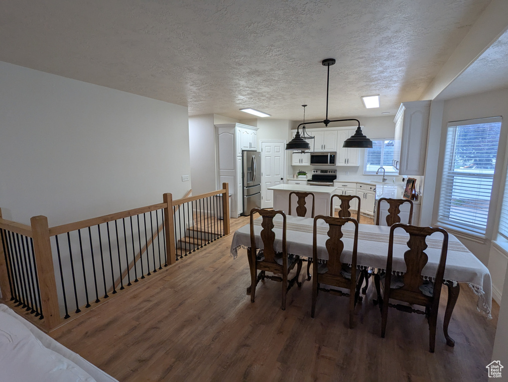 Dining area with wood finished floors and a textured ceiling