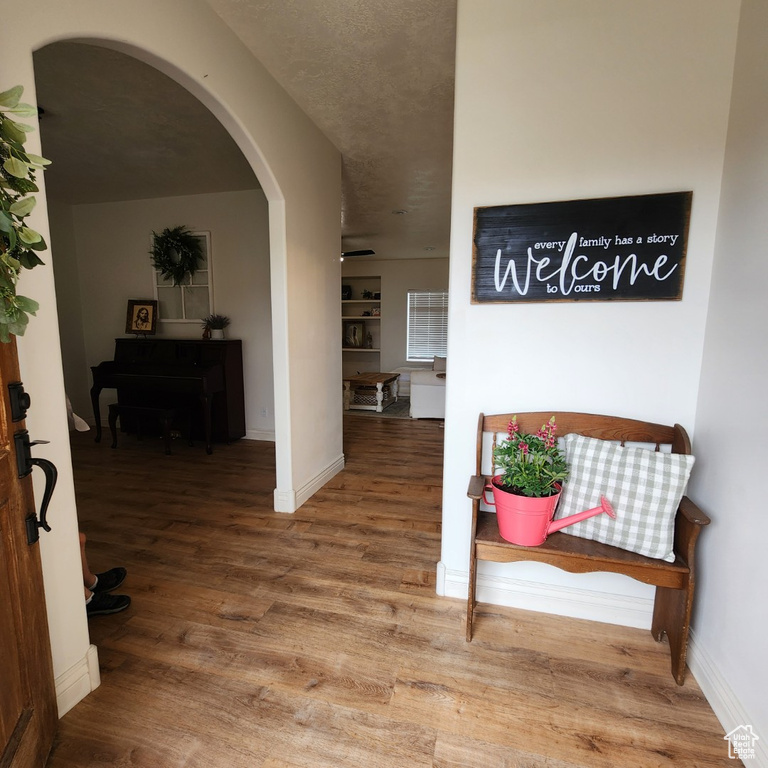Corridor with arched walkways and wood finished floors