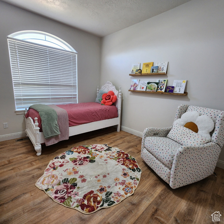 Bedroom with wood finished floors and baseboards