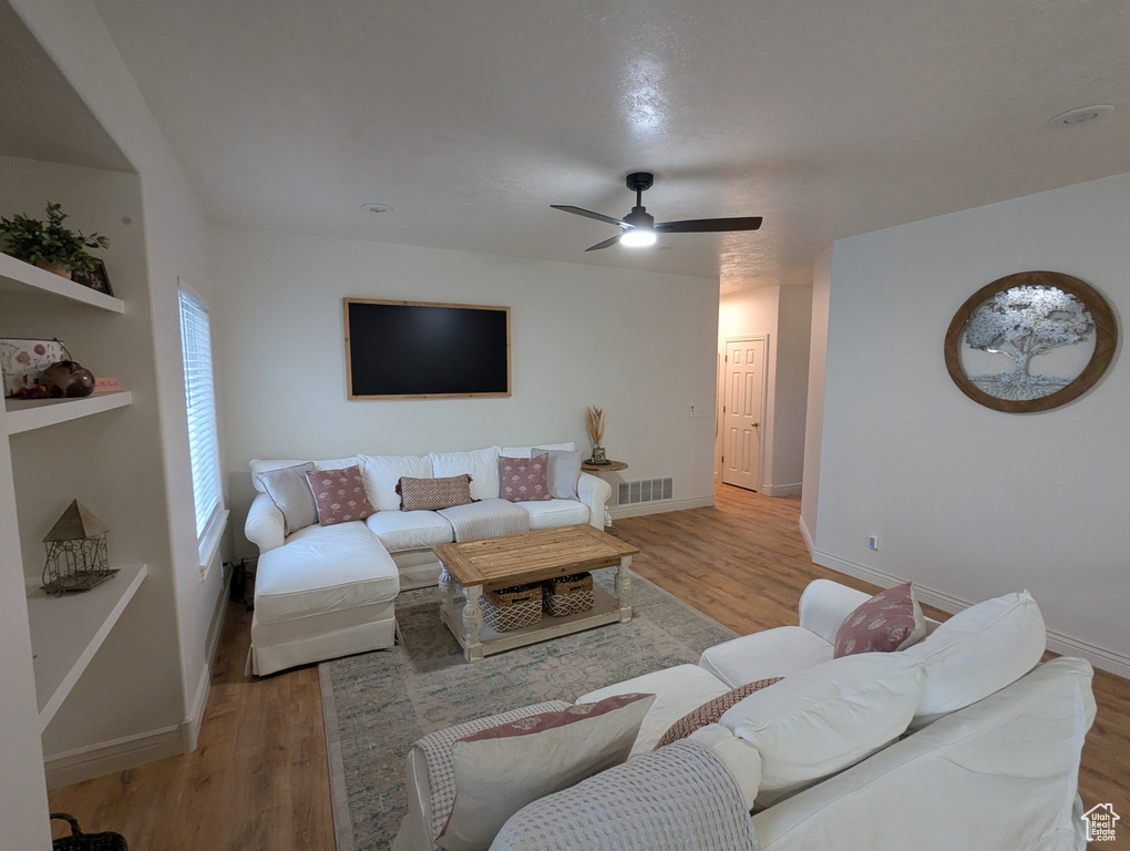 Living area featuring light wood finished floors and ceiling fan