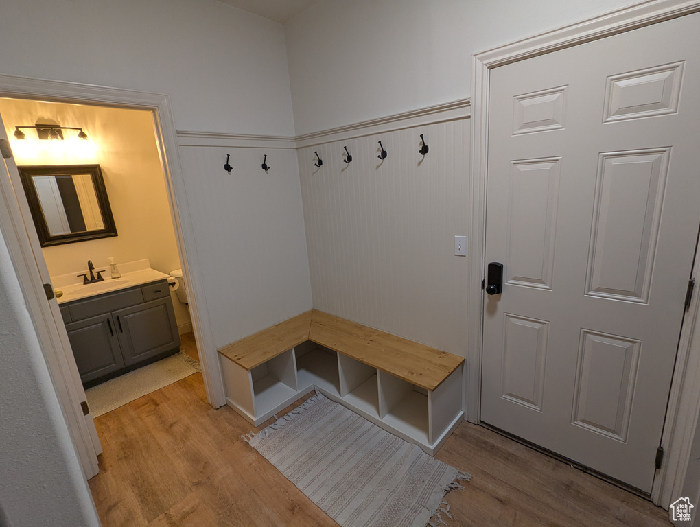 Mudroom with light wood-style floors and wainscoting
