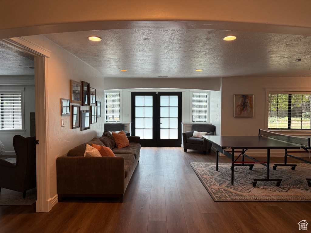 Living area featuring french doors, a textured ceiling, wood finished floors, and recessed lighting