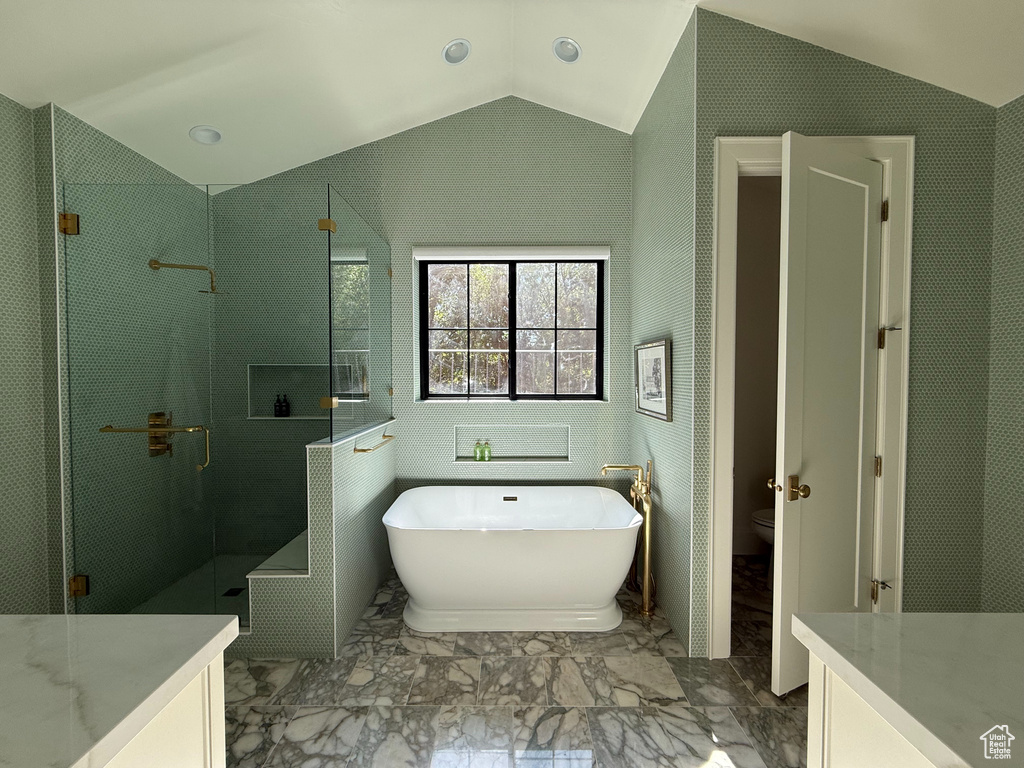 Bathroom with vanity, vaulted ceiling, a freestanding bath, a shower stall, and marble finish flooring