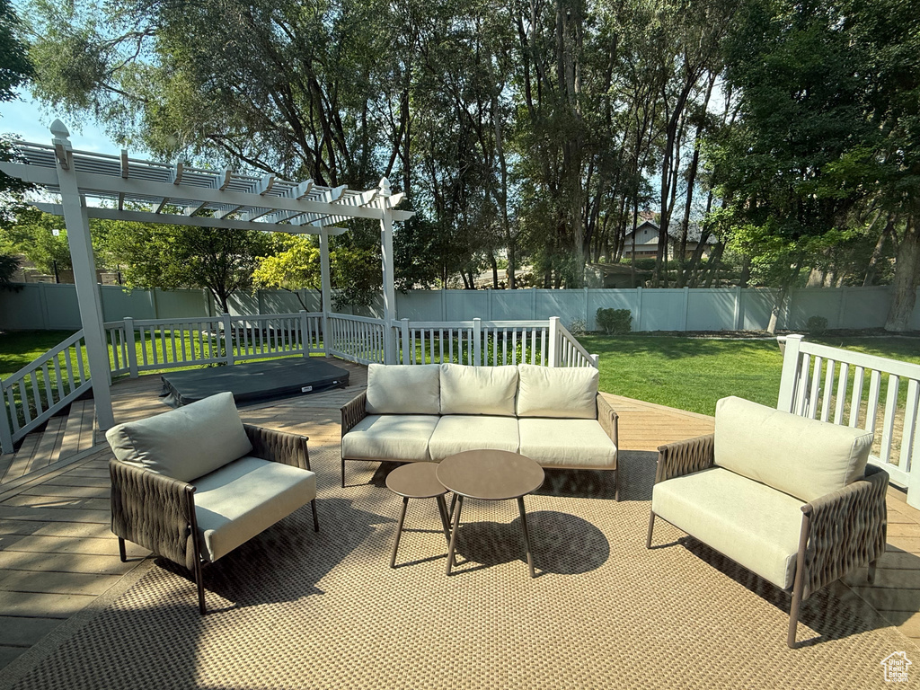 Fenced backyard featuring an outdoor hangout area, a wooden deck, and a pergola