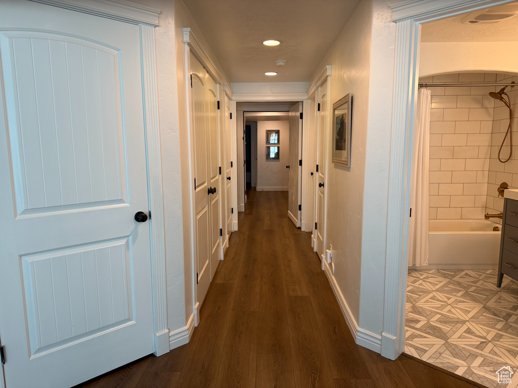 Hallway with dark wood-type flooring and recessed lighting