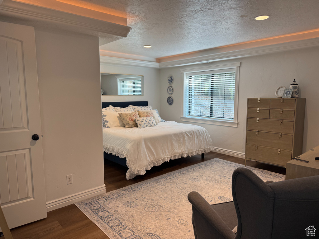 Bedroom featuring a textured ceiling, dark wood-style flooring, recessed lighting, and crown molding