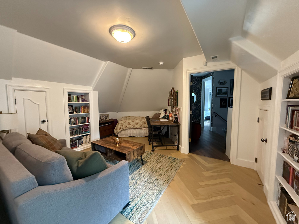 Living area featuring built in shelves and vaulted ceiling