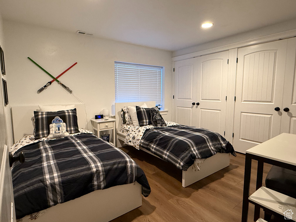 Bedroom featuring wood finished floors, a closet, and recessed lighting