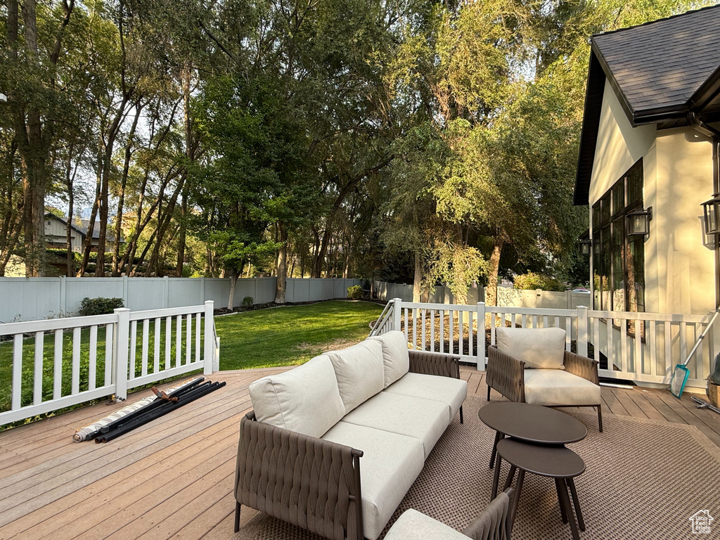 Wooden deck featuring a fenced backyard and outdoor lounge area