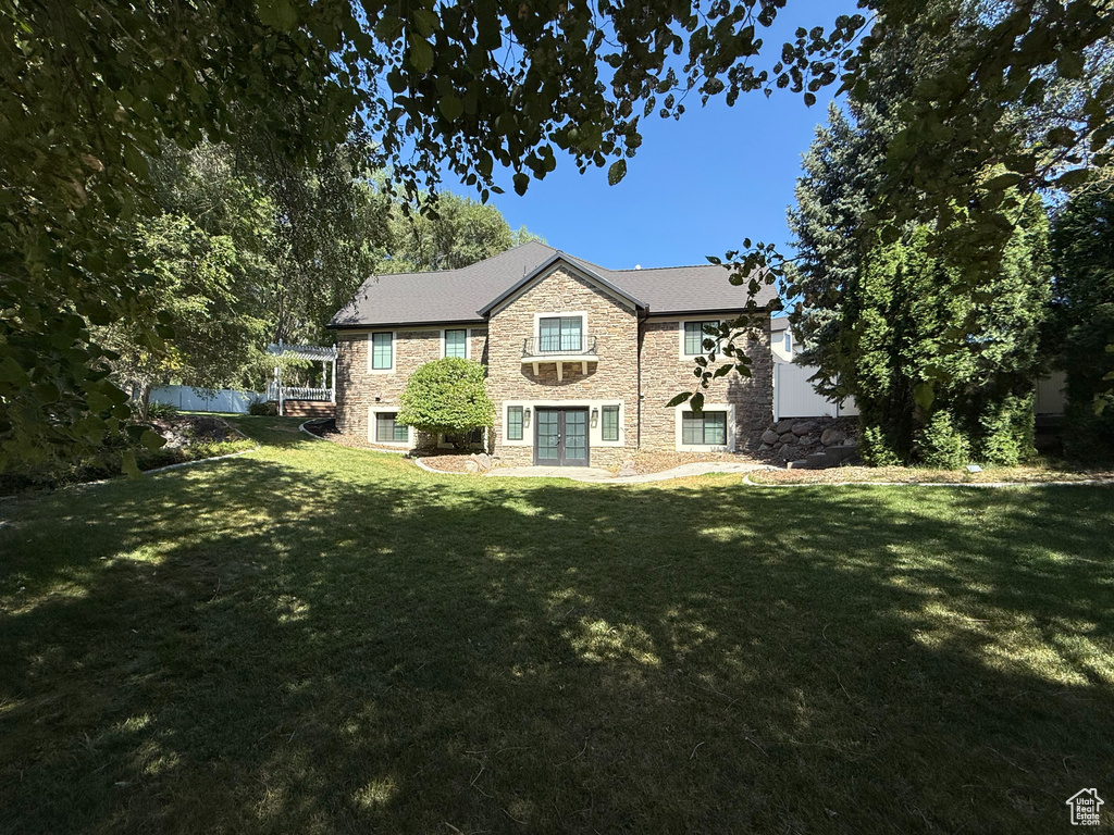 Back of property with french doors and stone siding