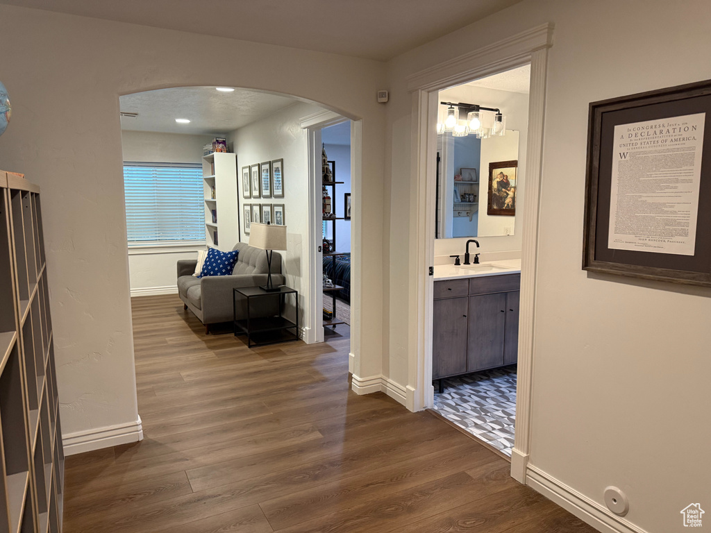 Hall with arched walkways and dark wood finished floors