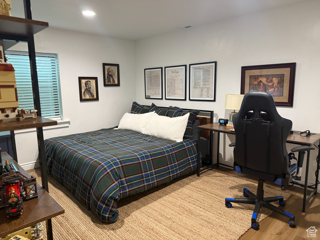 Bedroom featuring wood finished floors, an office area, and recessed lighting