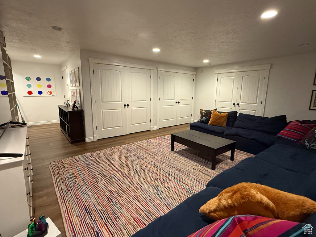 Living room with wood finished floors, recessed lighting, and a textured ceiling