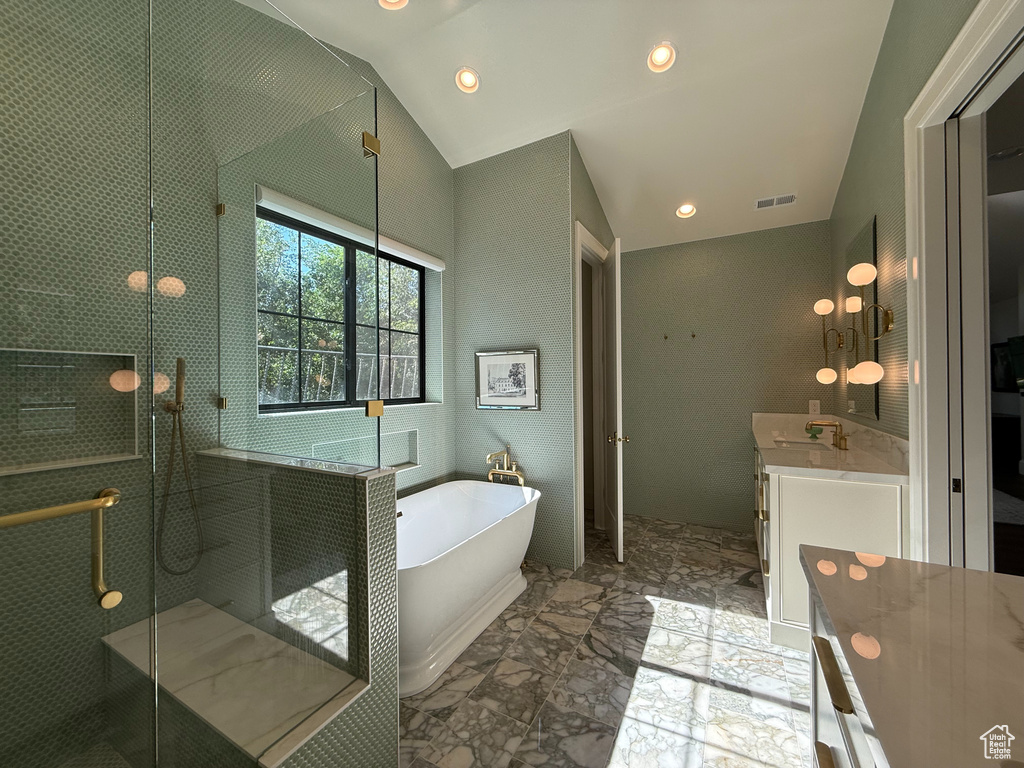 Full bath with a soaking tub, lofted ceiling, vanity, a shower stall, and marble finish flooring