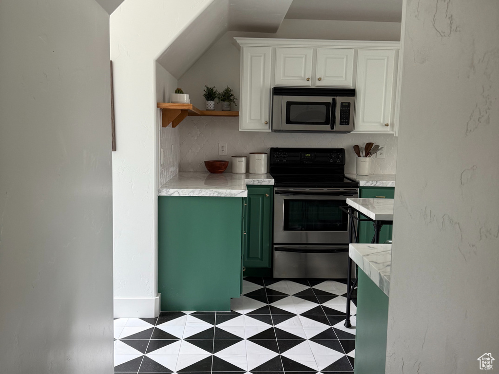 Kitchen with appliances with stainless steel finishes, light countertops, open shelves, white cabinetry, and green cabinets