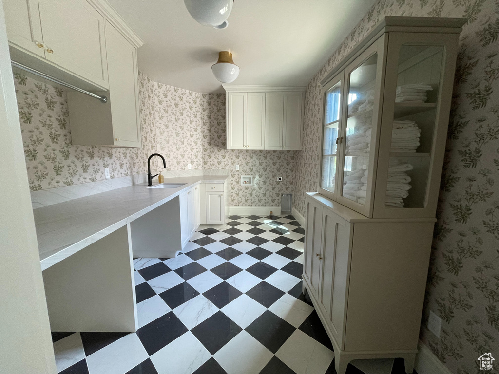 Kitchen featuring light flooring, white cabinetry, and light countertops