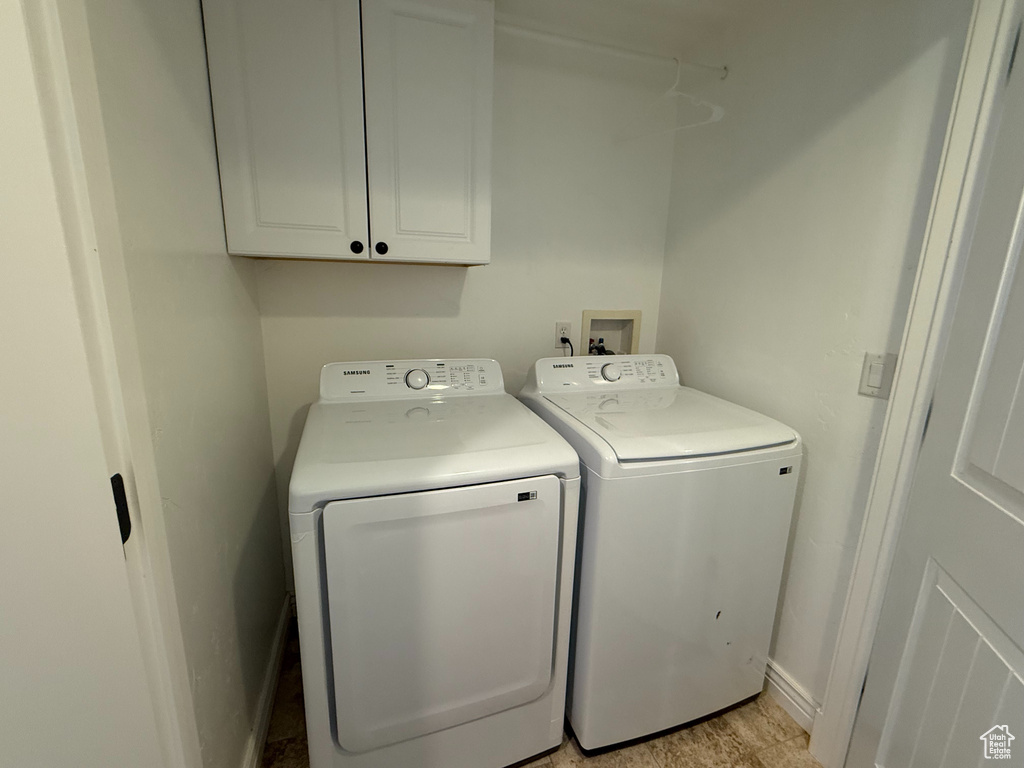 Laundry area featuring cabinet space and washer and clothes dryer