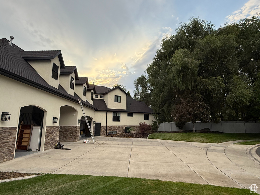 View of property exterior with stucco siding, stone siding, and a patio area
