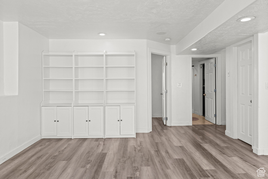 Unfurnished bedroom with wood finished floors, a textured ceiling, recessed lighting, and a closet