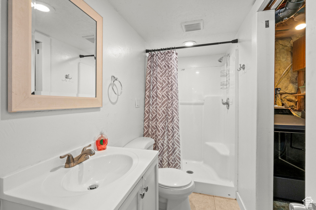 Full bathroom with vanity, a shower with shower curtain, tile patterned flooring, and washer / clothes dryer