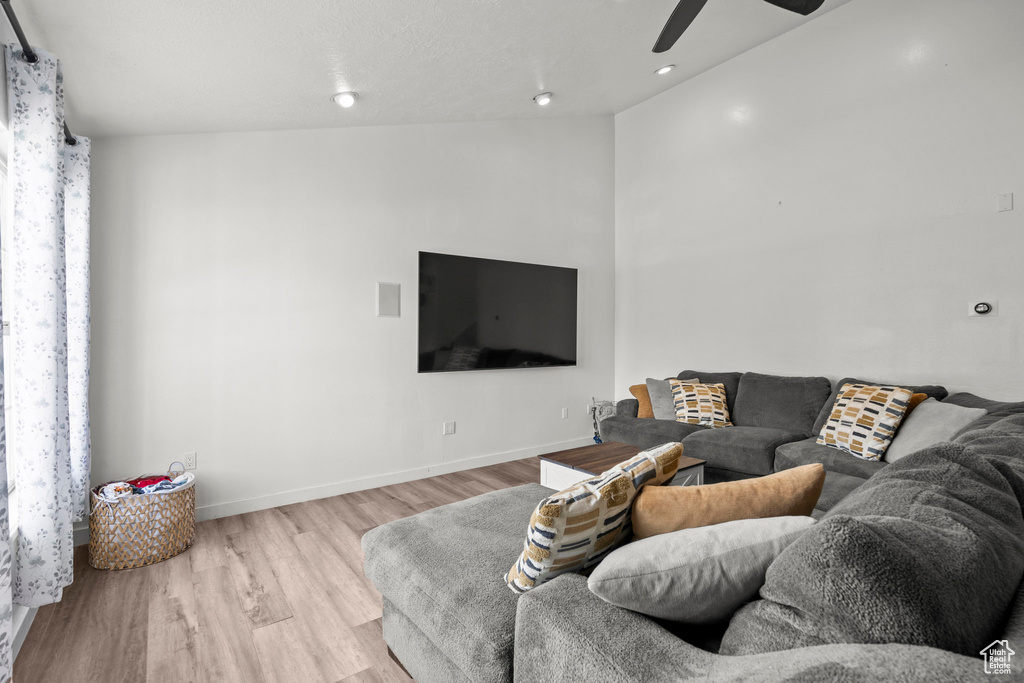 Living room with wood finished floors, ceiling fan, and recessed lighting