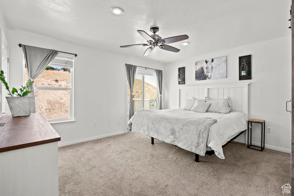 Bedroom featuring access to exterior, carpet, ceiling fan, and a textured ceiling
