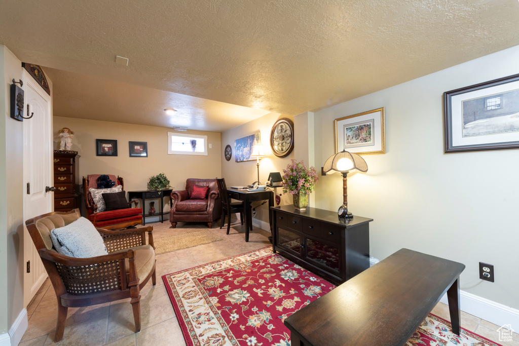 Living area featuring a textured ceiling and light tile patterned flooring