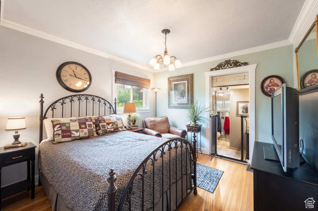 Bedroom featuring a chandelier, ornamental molding, and light wood-style flooring