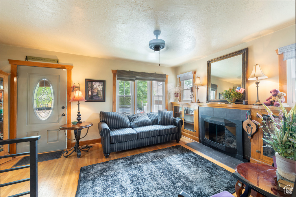 Living room featuring hardwood / wood-style flooring, a textured ceiling, and a fireplace