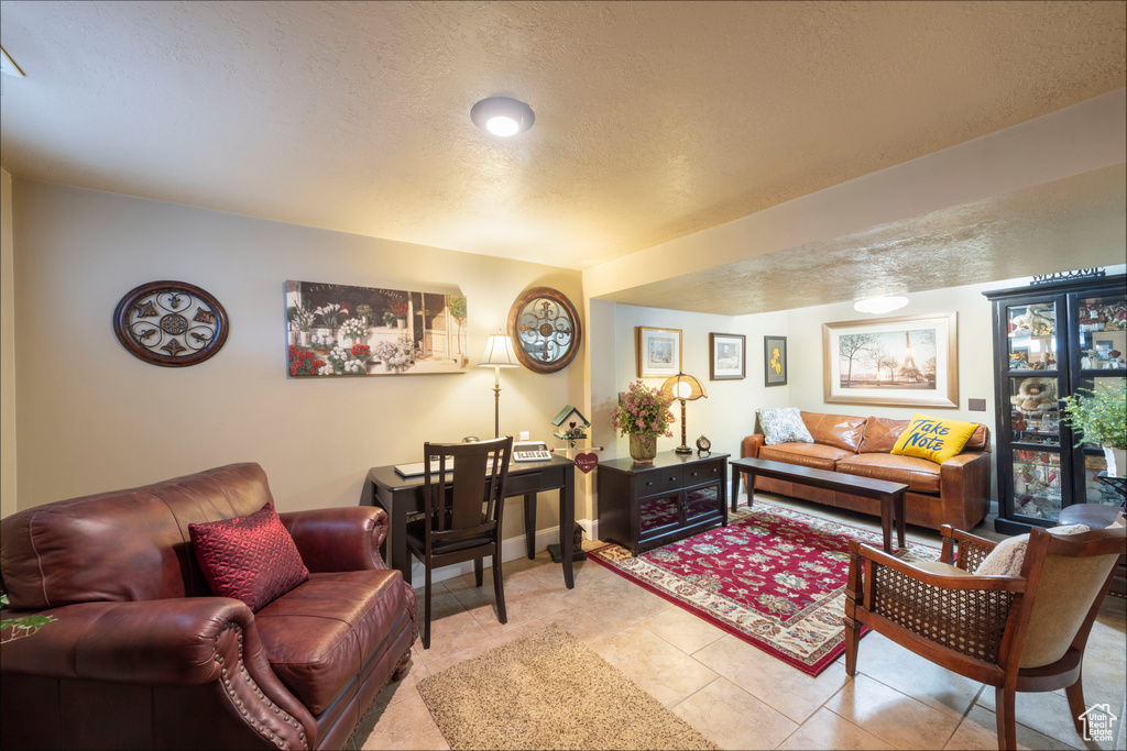 Living area featuring a textured ceiling and light tile patterned floors
