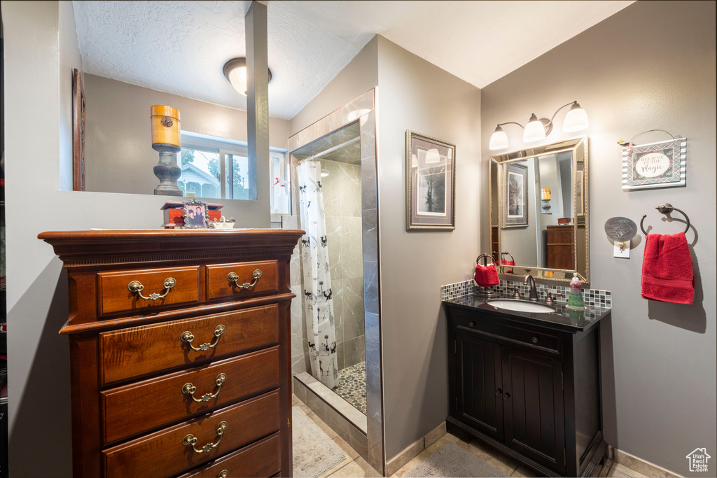 Bathroom featuring a shower stall and vanity