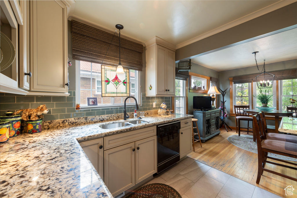 Kitchen featuring black dishwasher, tasteful backsplash, a chandelier, decorative light fixtures, and crown molding