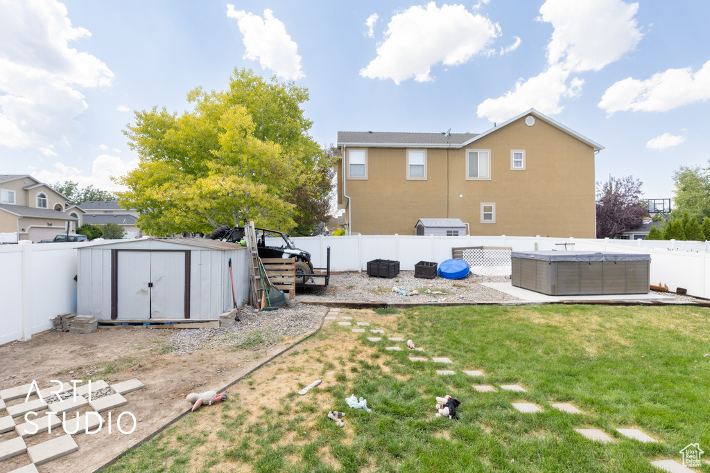Fenced backyard featuring a shed