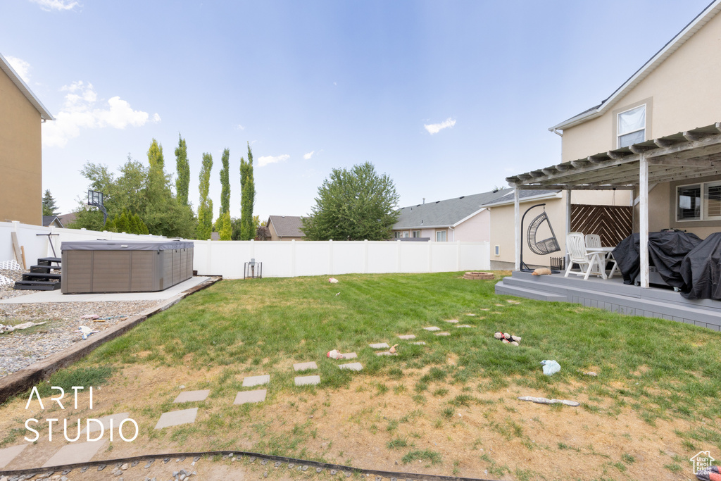 Fenced backyard with a hot tub, a pergola, and a wooden deck