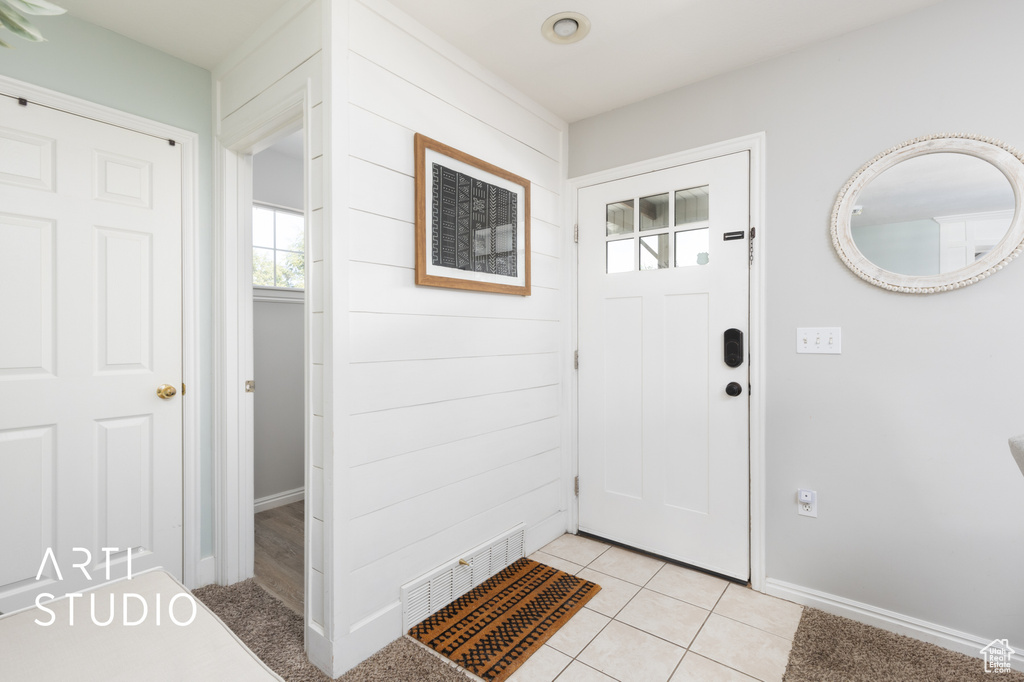 Entryway featuring baseboards and light tile patterned floors
