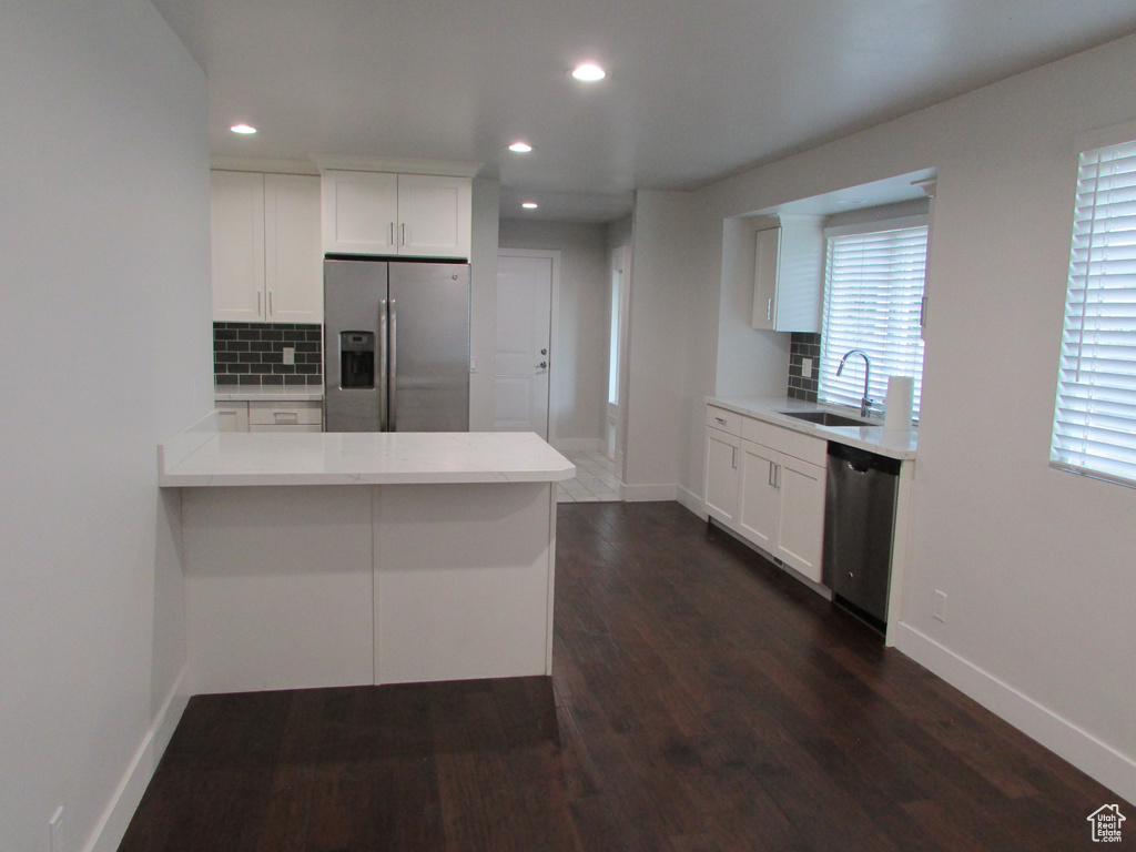 Kitchen featuring stainless steel appliances, decorative backsplash, recessed lighting, and light countertops