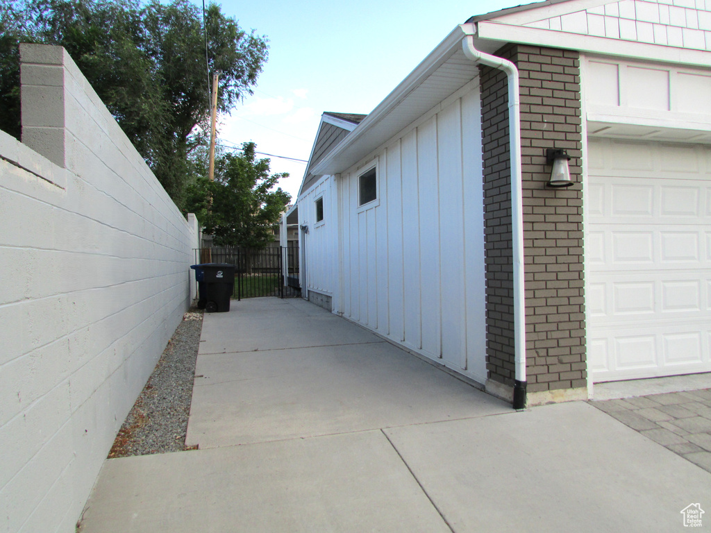 View of side of home with brick siding, a garage, and board and batten siding