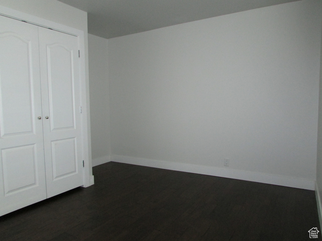 Unfurnished bedroom with a closet and dark wood finished floors