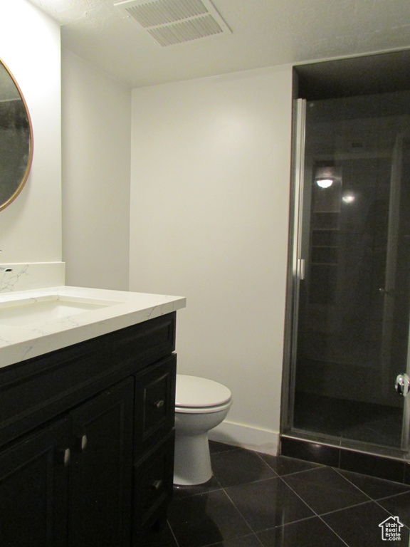 Bathroom featuring vanity, a stall shower, and tile patterned flooring