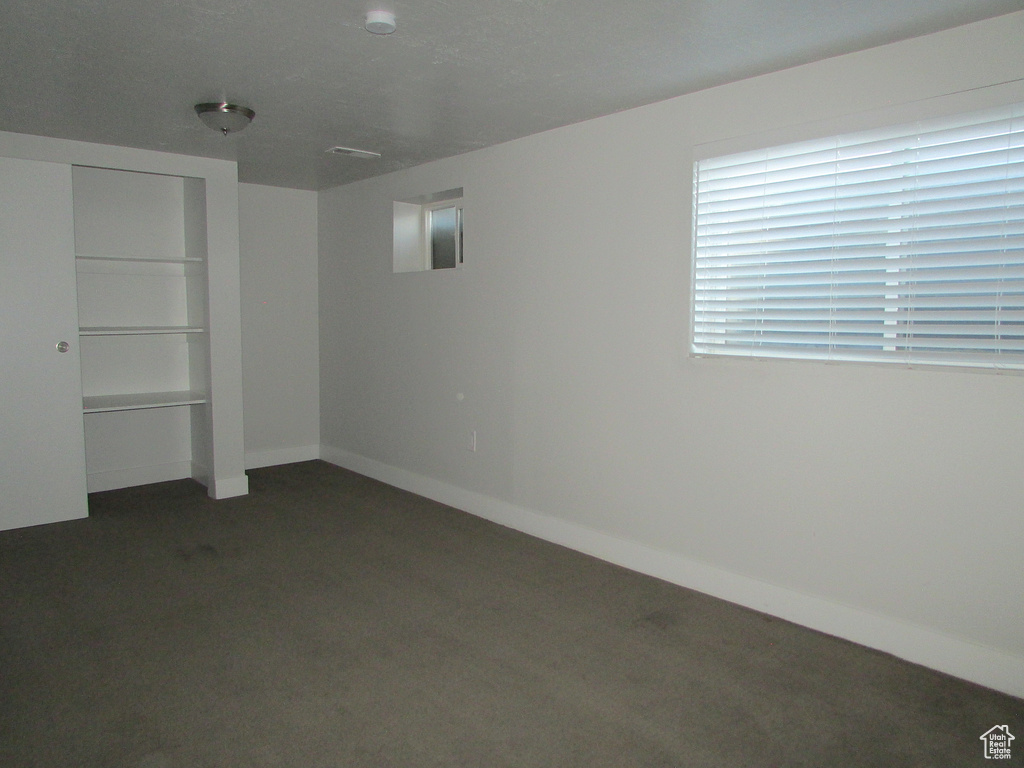 Unfurnished bedroom with dark colored carpet and a closet