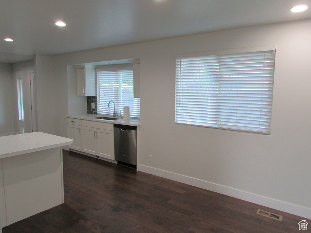 Kitchen featuring recessed lighting, dark wood-type flooring, dishwasher, white cabinets, and backsplash