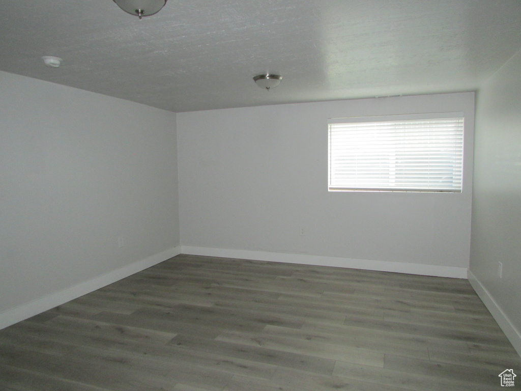 Unfurnished room featuring wood finished floors and baseboards