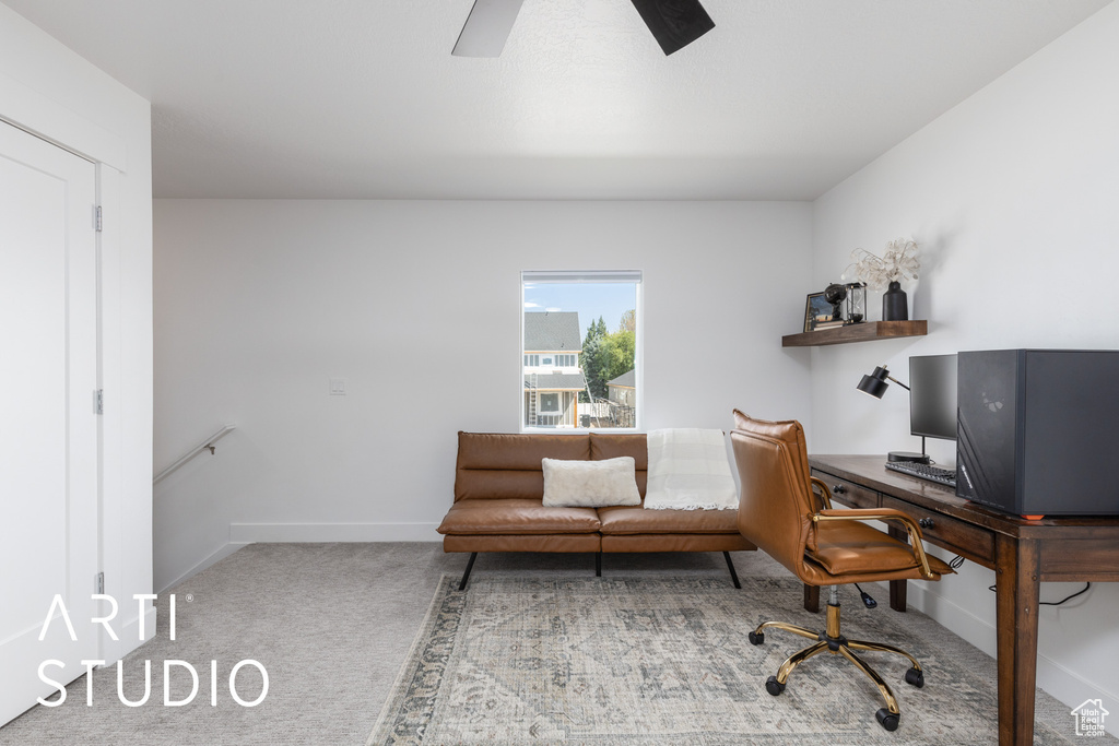 Carpeted office with a ceiling fan and baseboards