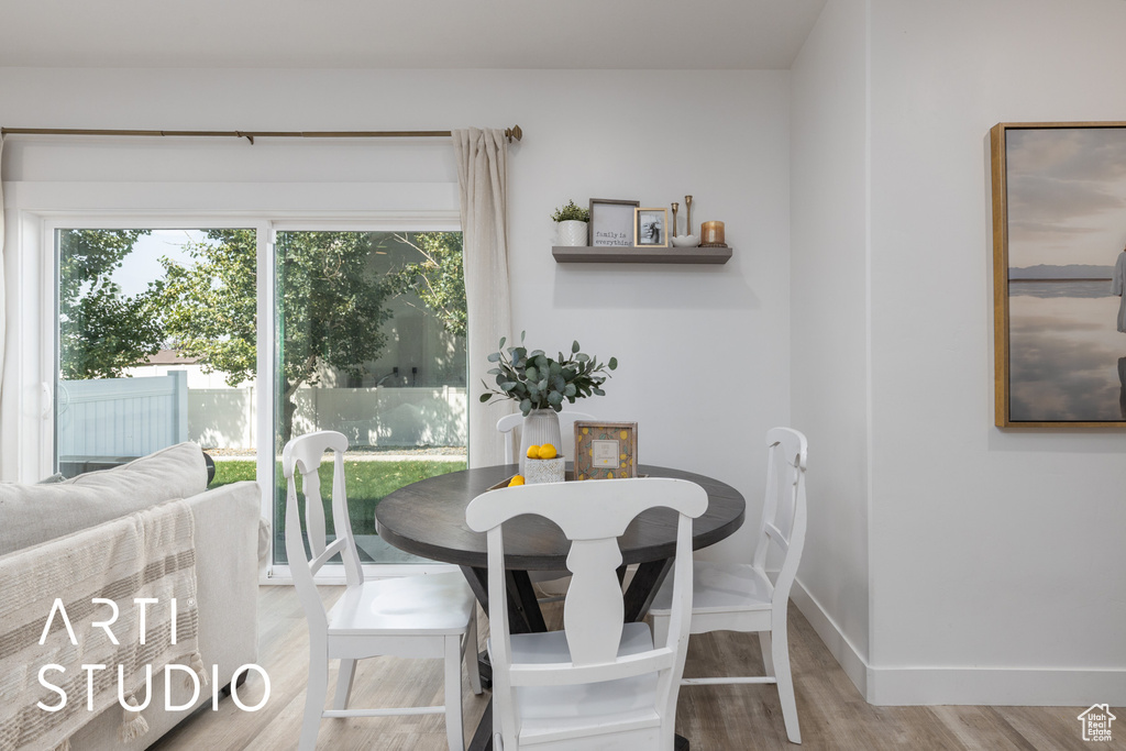 Dining room with wood finished floors and healthy amount of natural light