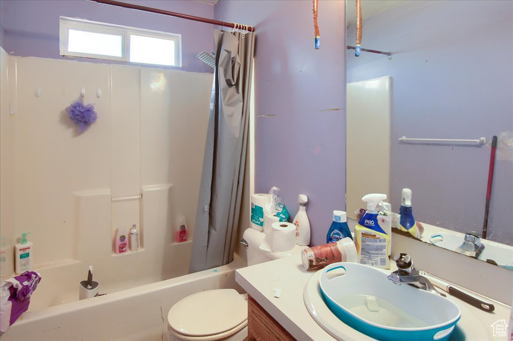 Full bath with shower / tub combo with curtain and vanity