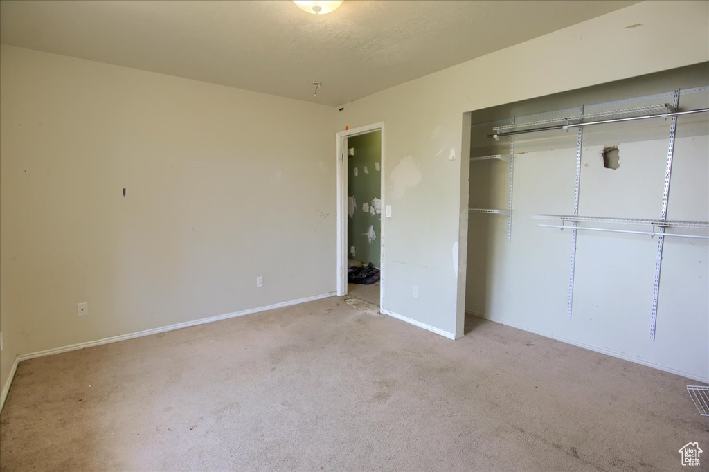 Unfurnished bedroom featuring carpet floors and a closet