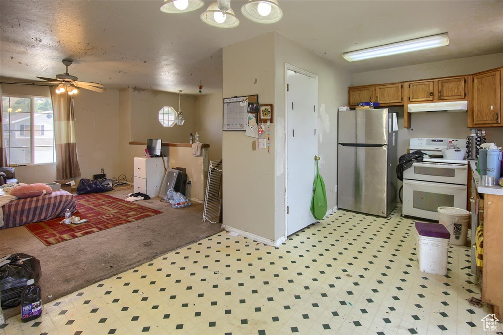 Kitchen featuring light floors, freestanding refrigerator, white electric stove, ceiling fan, and open floor plan