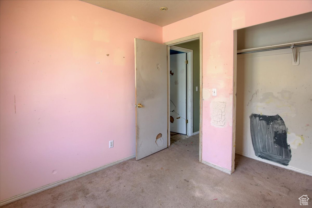 Unfurnished bedroom with carpet and a closet
