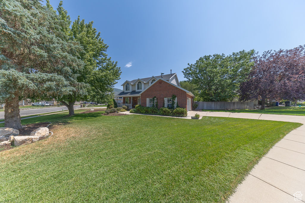 View of front of home with driveway, brick siding, and an attached garage