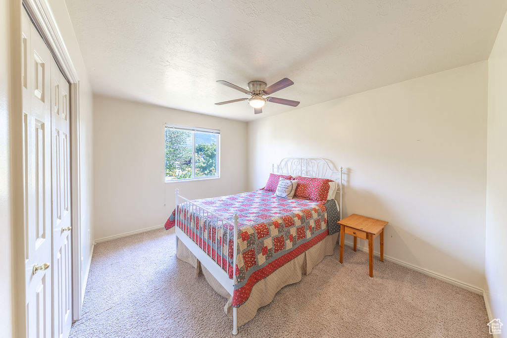 Bedroom with light colored carpet and ceiling fan